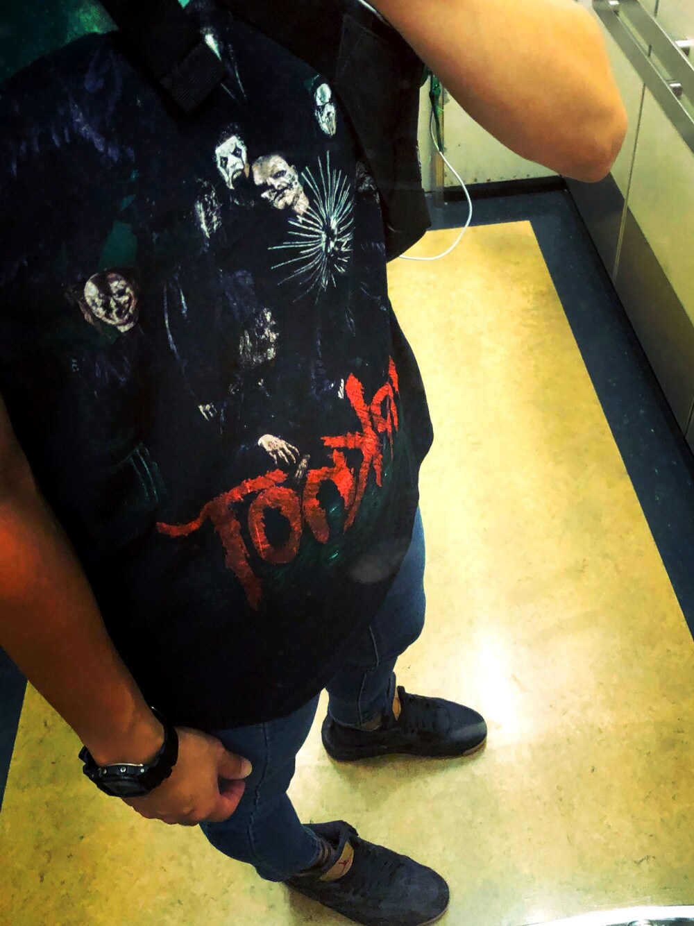 ブラック系のTシャツ/カットソー、ブラック系のスニーカー、ブルー系のデニムパンツを着用したメンズの秋コーディネートの1枚目の写真