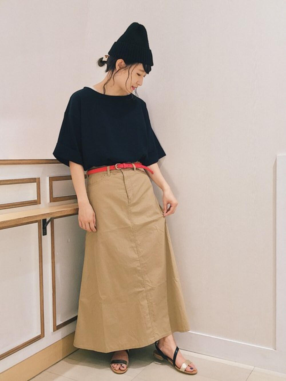 ベージュ系のスカート、ブラック系のTシャツ/カットソー、ブラック系のサンダルを着用したレディースの夏コーディネートの1枚目の写真