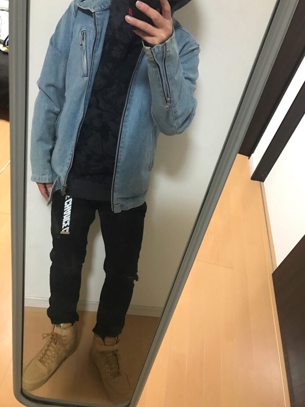 ブルー系のデニムジャケット、ブラック系のパーカー、ブラック系のデニムパンツを着用したメンズの冬コーディネートの1枚目の写真