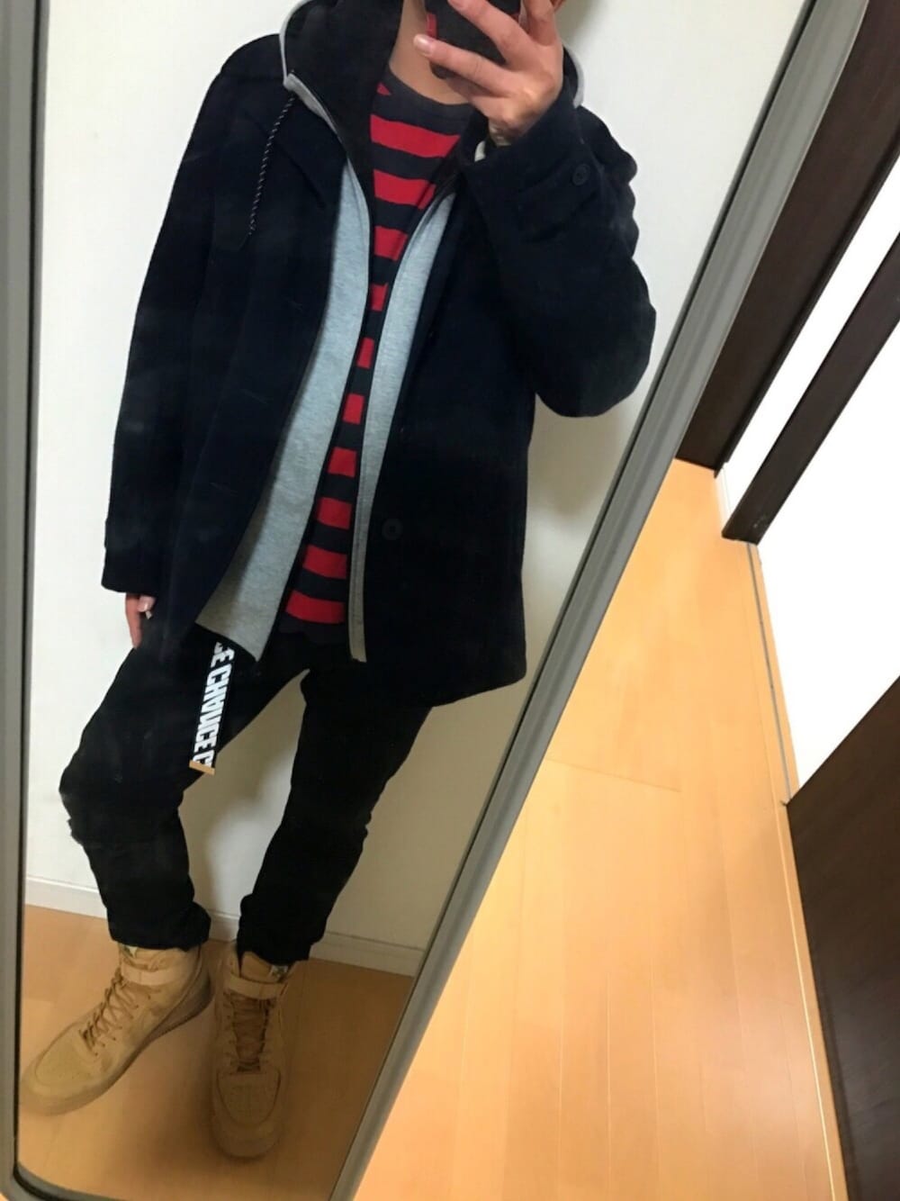 ブルー系のピーコート、グレー系のパーカー、レッド系のTシャツ/カットソーを着用したメンズの冬コーディネートの1枚目の写真