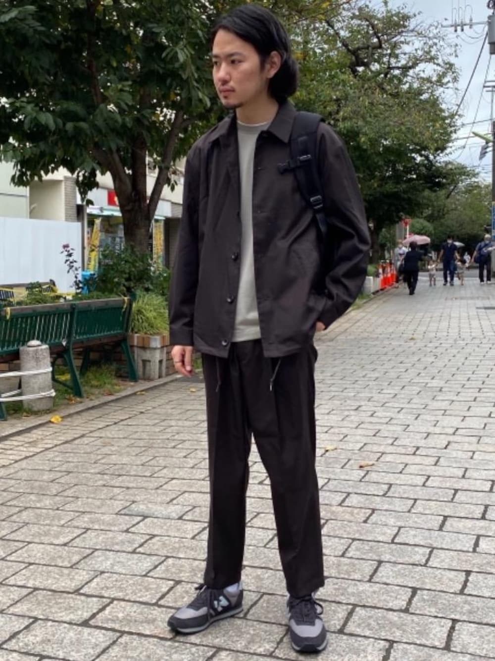 グレー系のスニーカー、ブラウン系のその他パンツ、ブラウン系のブルゾンを着用したメンズの秋コーディネートの1枚目の写真