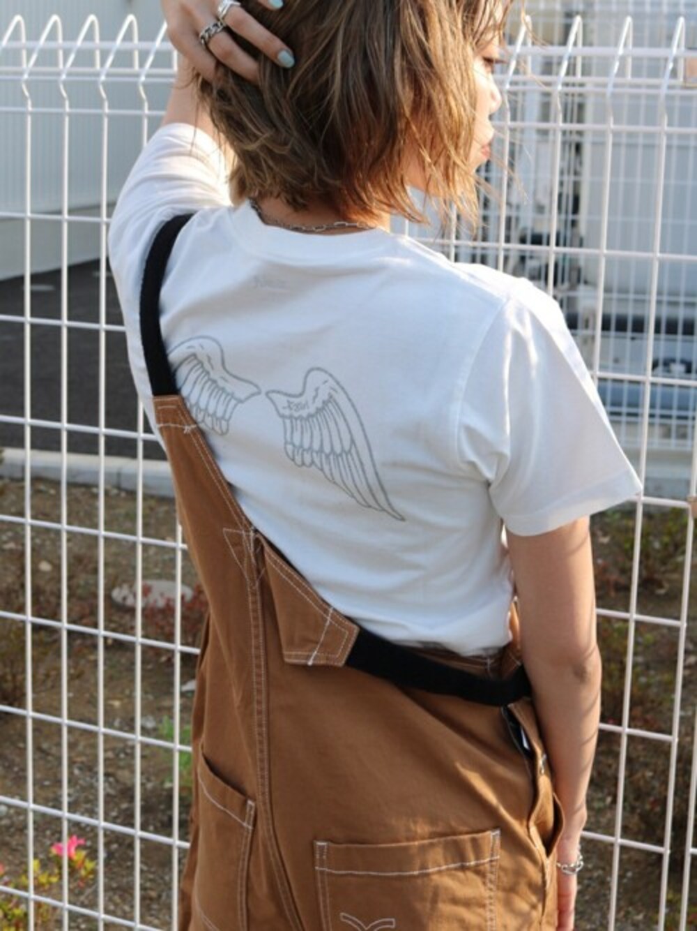 ベージュ系のサロペット/オーバーオール、ホワイト系のTシャツ/カットソーを着用したレディースの春コーディネートの1枚目の写真