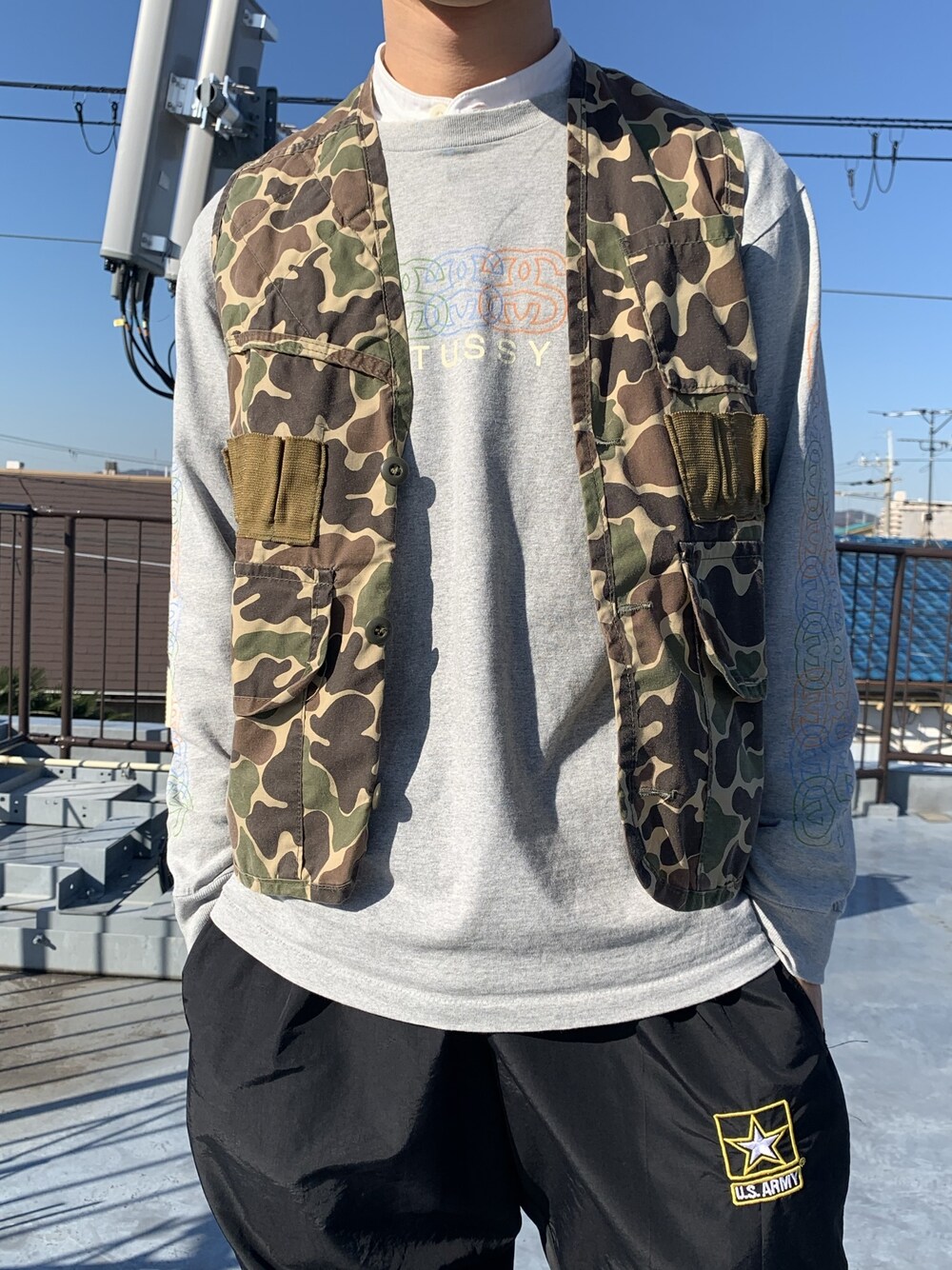 グリーン系のベスト、グレー系のTシャツ/カットソーを着用したメンズの冬コーディネートの1枚目の写真
