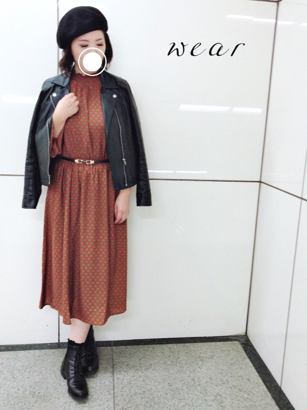 オレンジ系のワンピース、ブラック系のライダースジャケット、ブラック系のブーツを着用したレディースの秋コーディネートの1枚目の写真