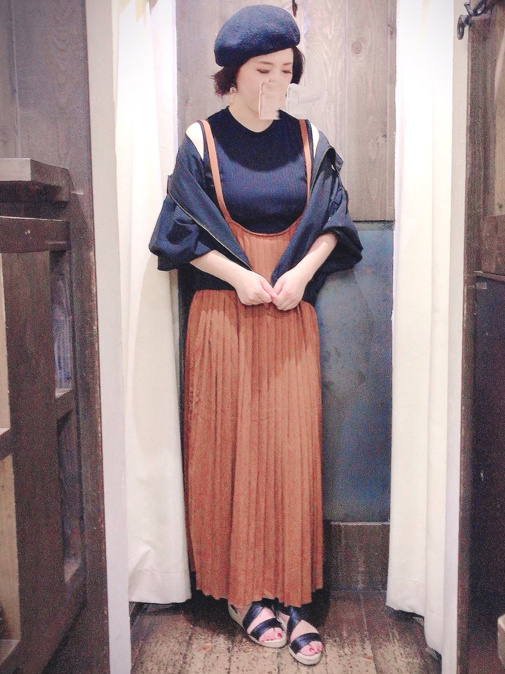 イエロー系のジャンパースカート、ブラック系のブルゾンを着用したレディースの夏コーディネートの1枚目の写真