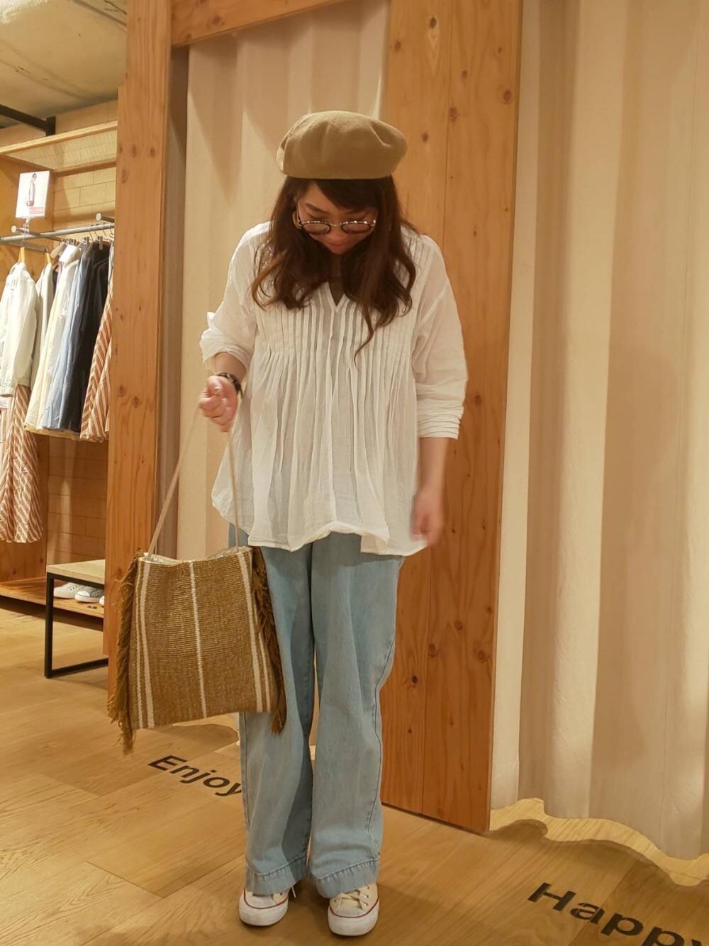 イエロー系のトートバッグ、ホワイト系のシャツ/ブラウス、ブルー系のデニムパンツを着用したレディースの春コーディネートの1枚目の写真