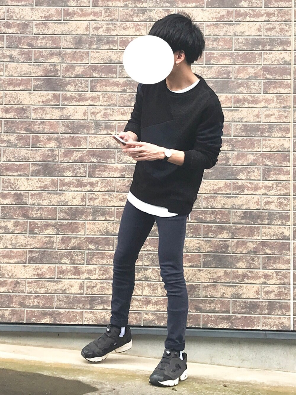 ブラック系のニット/セーター、ホワイト系のTシャツ/カットソー、ブラック系のスニーカーを着用したメンズの秋コーディネートの1枚目の写真