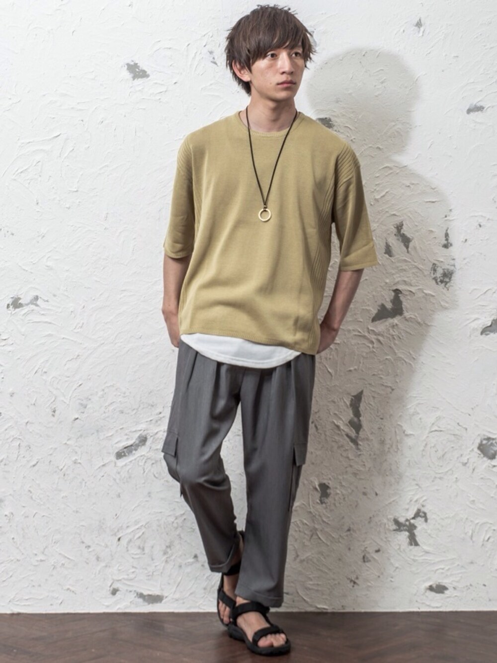 ブルー系のニット/セーター、ブラック系のタンクトップ、シルバー系のネックレスを着用したメンズの春コーディネートの1枚目の写真