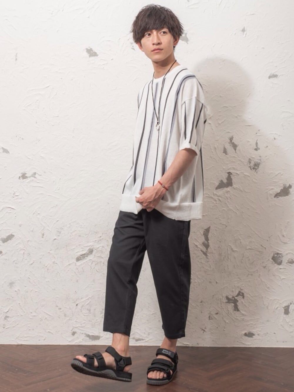 ブラック系のニット/セーター、ベージュ系のその他パンツ、シルバー系のネックレスを着用したメンズの夏コーディネートの1枚目の写真