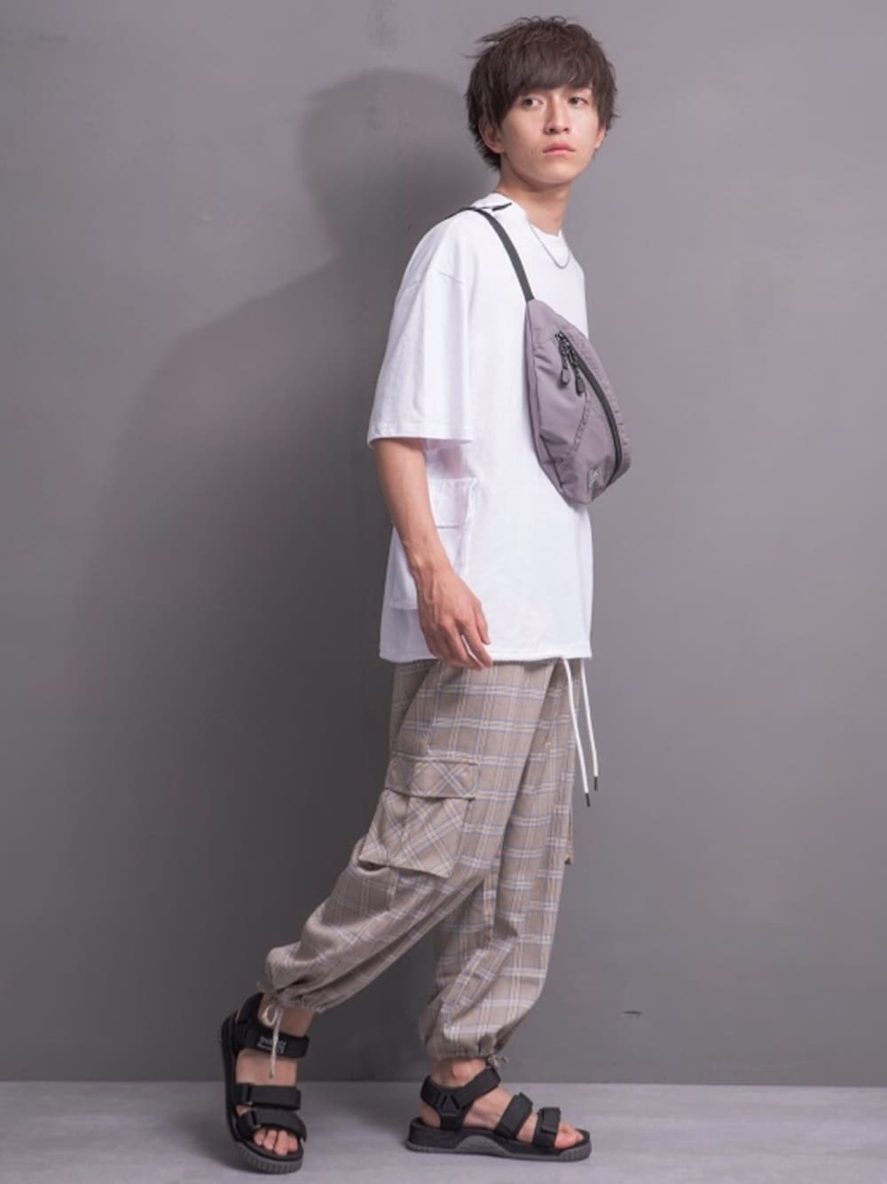 ホワイト系のTシャツ/カットソー、ブラック系のボディバッグ/ウエストポーチ、ベージュ系のカーゴパンツを着用したメンズの夏コーディネートの1枚目の写真