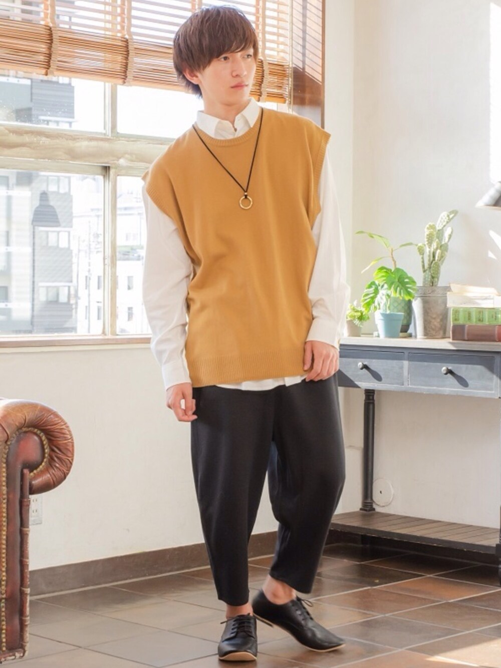 グレー系のベスト、ブラック系のスウェットパンツ、シルバー系のネックレスを着用したメンズの秋コーディネートの1枚目の写真