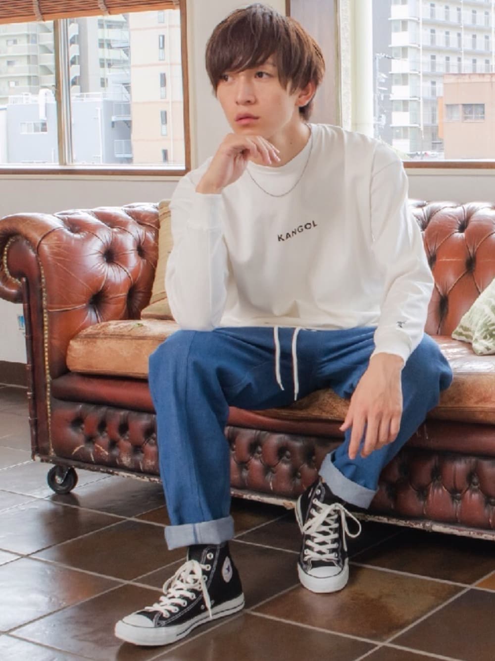 ベージュ系のTシャツ/カットソー、ブルー系のデニムパンツを着用したメンズの秋コーディネートの1枚目の写真