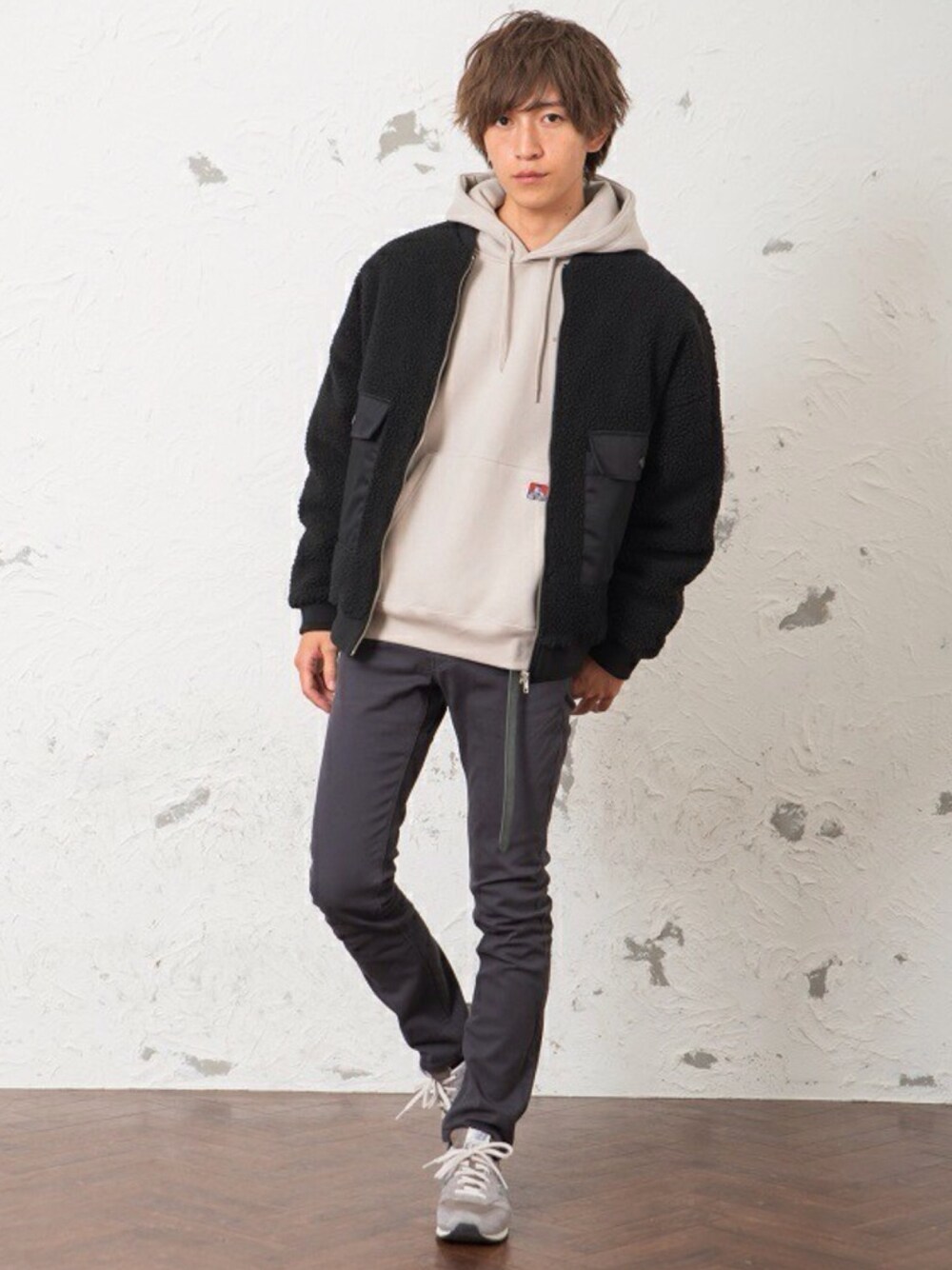 パープル系のミリタリージャケット、ブルー系のチノパンツ、ホワイト系のパーカーを着用したメンズの冬コーディネートの1枚目の写真