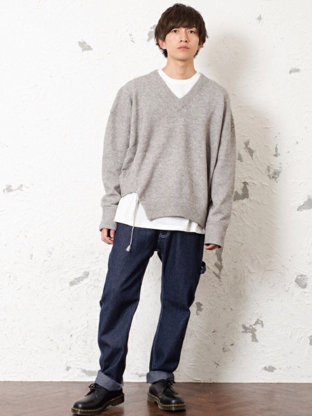 ベージュ系のニット/セーター、ホワイト系のTシャツ/カットソー、ブルー系のチノパンツを着用したメンズの秋コーディネートの1枚目の写真