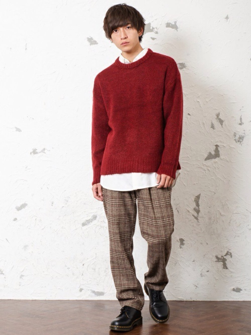 ブラウン系のニット/セーター、ホワイト系のTシャツ/カットソー、ブラック系のスラックスを着用したメンズの冬コーディネートの1枚目の写真