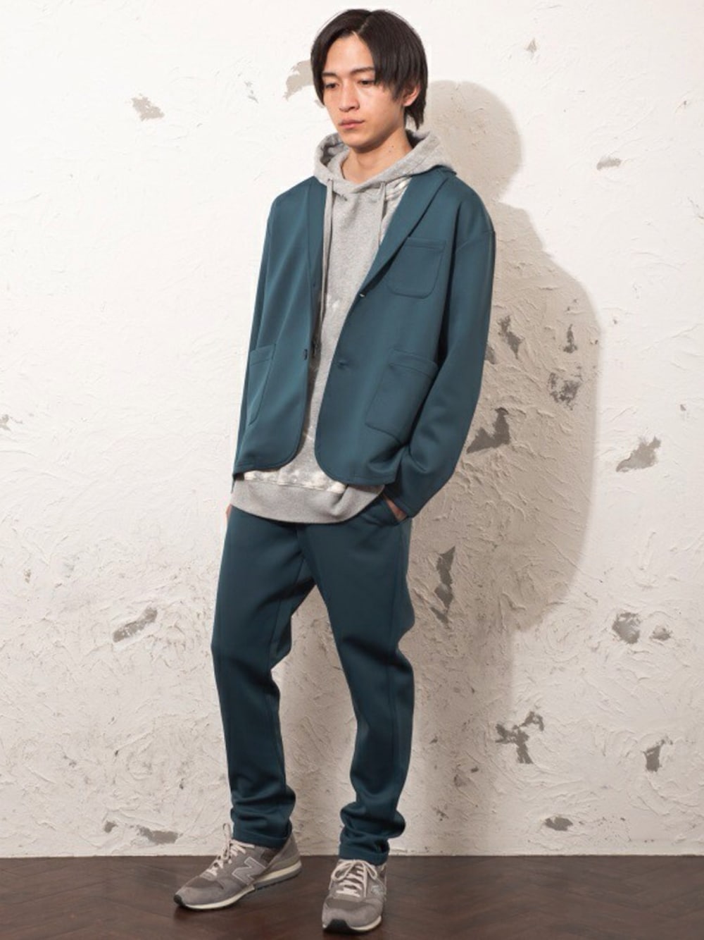 グリーン系のテーラードジャケット、グリーン系のスラックス、ブラック系のパーカーを着用したメンズの冬コーディネートの1枚目の写真
