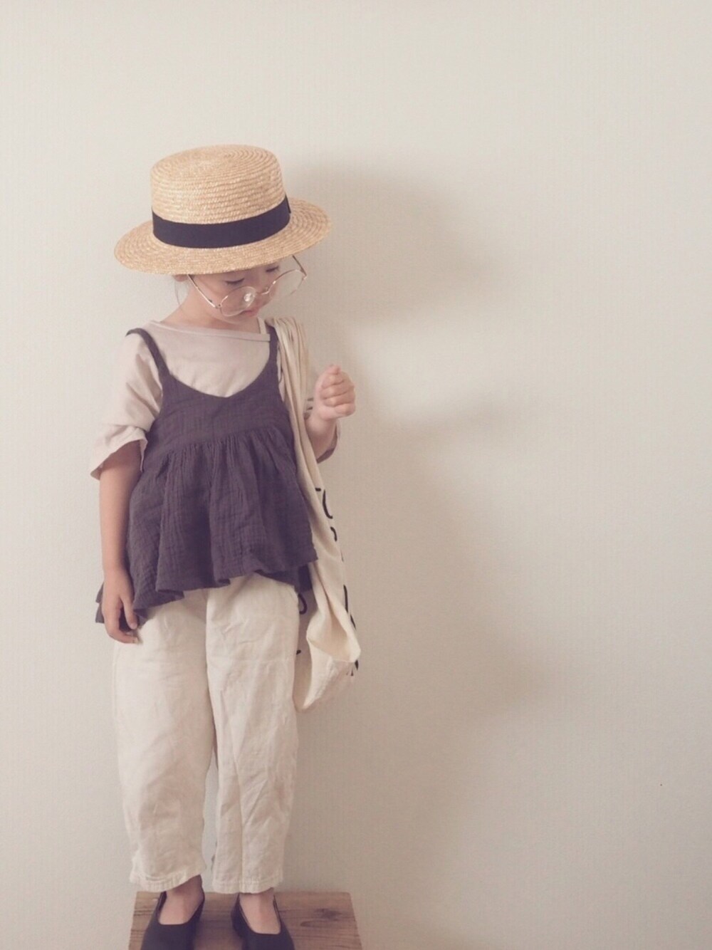 グレー系のトップス、ホワイト系のエコバッグ/サブバッグ、ベージュ系のハットを着用したキッズの夏コーディネートの1枚目の写真