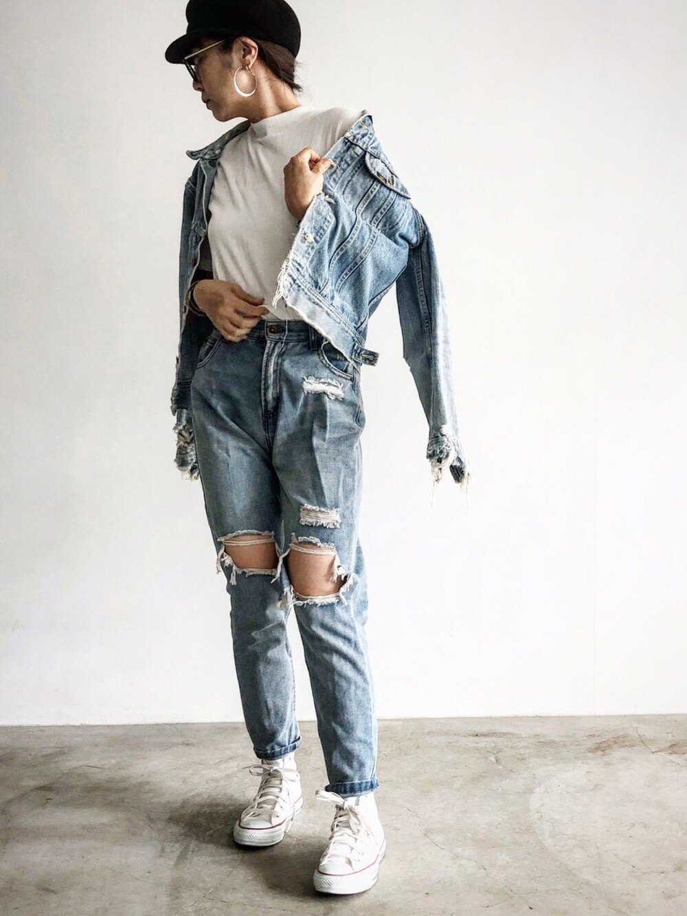 ブルー系のデニムジャケット、ブルー系のデニムパンツ、ホワイト系のスニーカーを着用したレディースの秋コーディネートの1枚目の写真