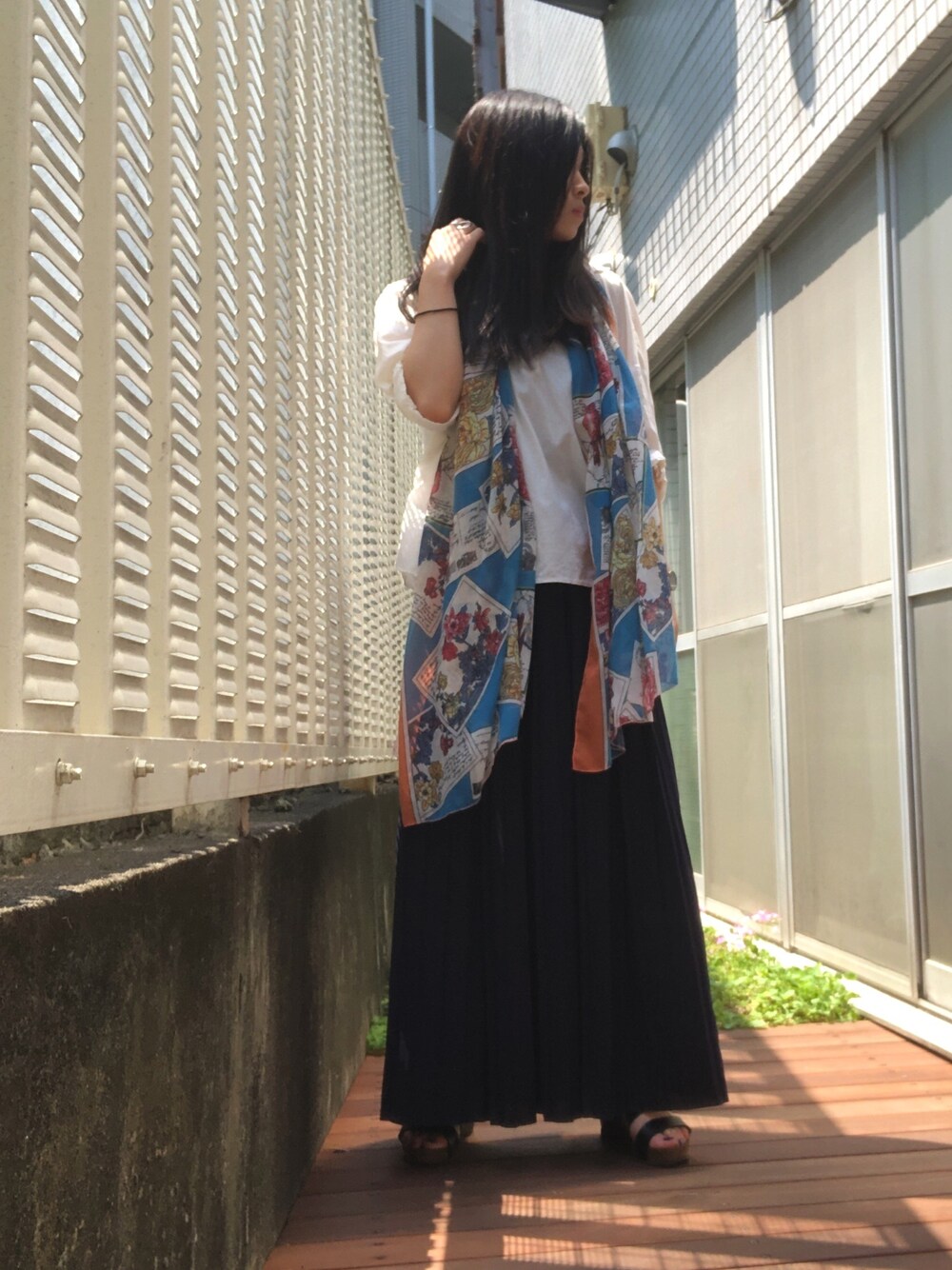 ブルー系のスカート、ホワイト系のシャツ/ブラウス、オレンジ系のストール/ショールを着用したレディースの夏コーディネートの1枚目の写真