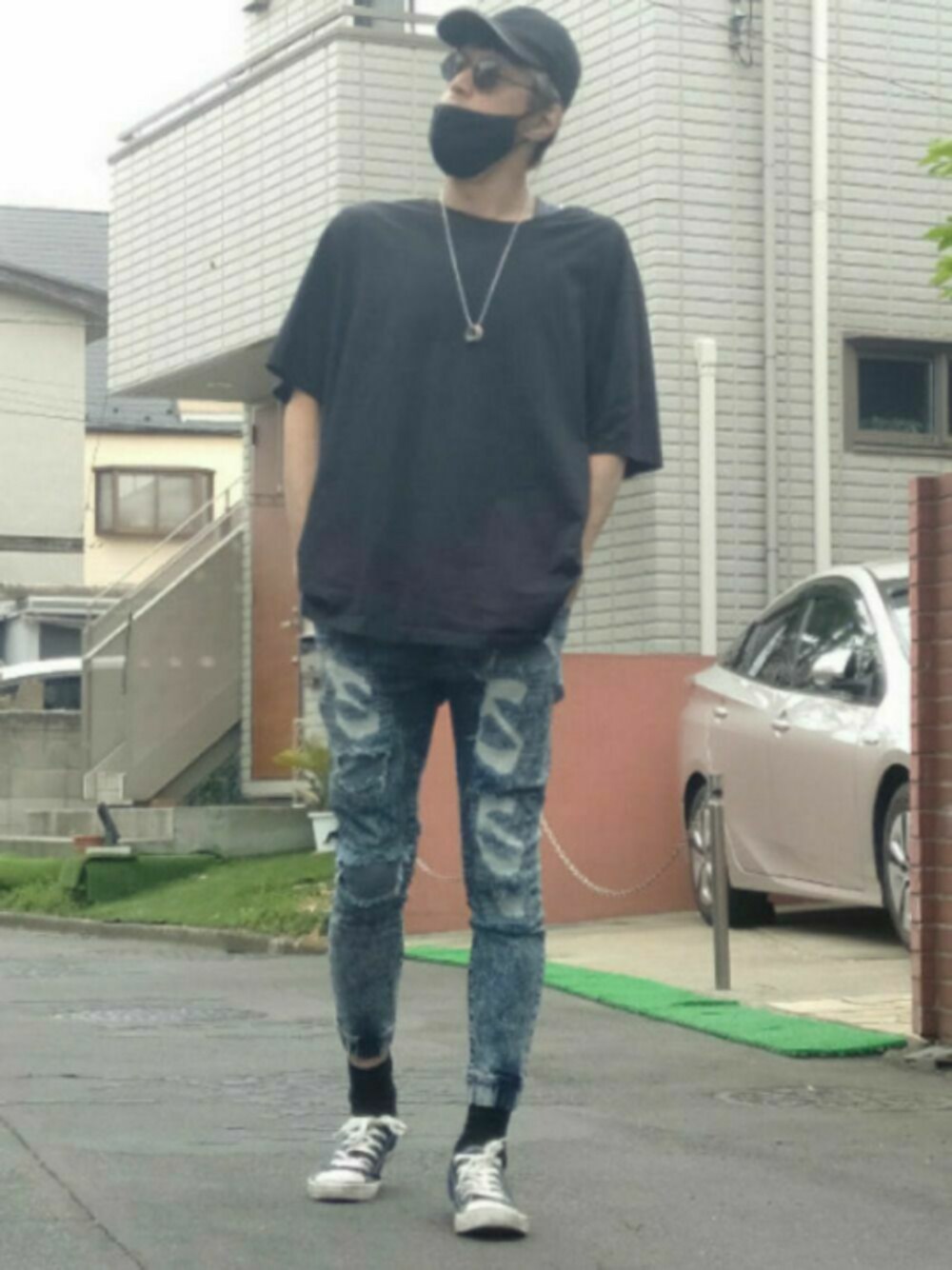ホワイト系のスニーカー、ブルー系のデニムパンツ、ブラック系のTシャツ/カットソーを着用したメンズの春コーディネートの1枚目の写真