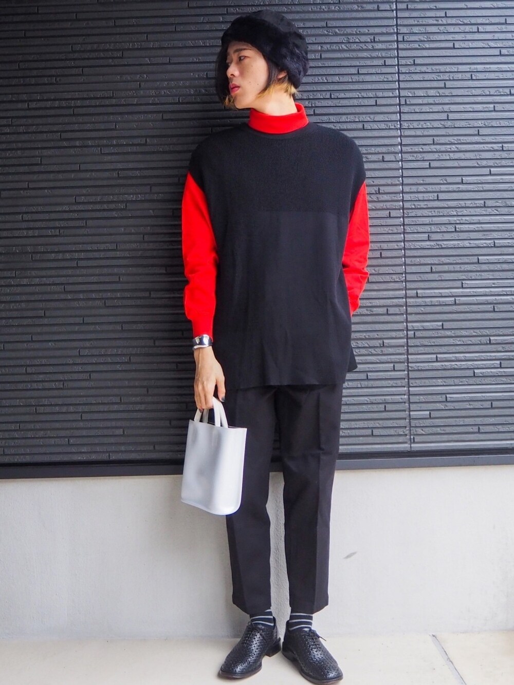 オレンジ系のTシャツ/カットソー、ブラック系のニット/セーター、ブラック系のパンツを着用したメンズの秋コーディネートの1枚目の写真