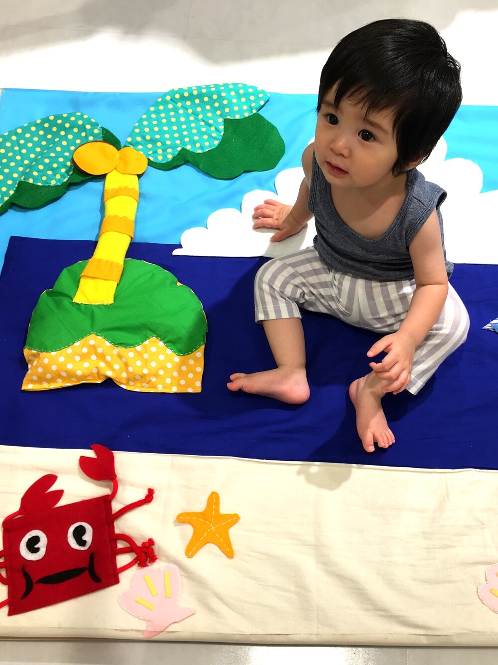 ブルー系のタンクトップ、ホワイト系のパンツを着用したキッズの夏コーディネートの1枚目の写真