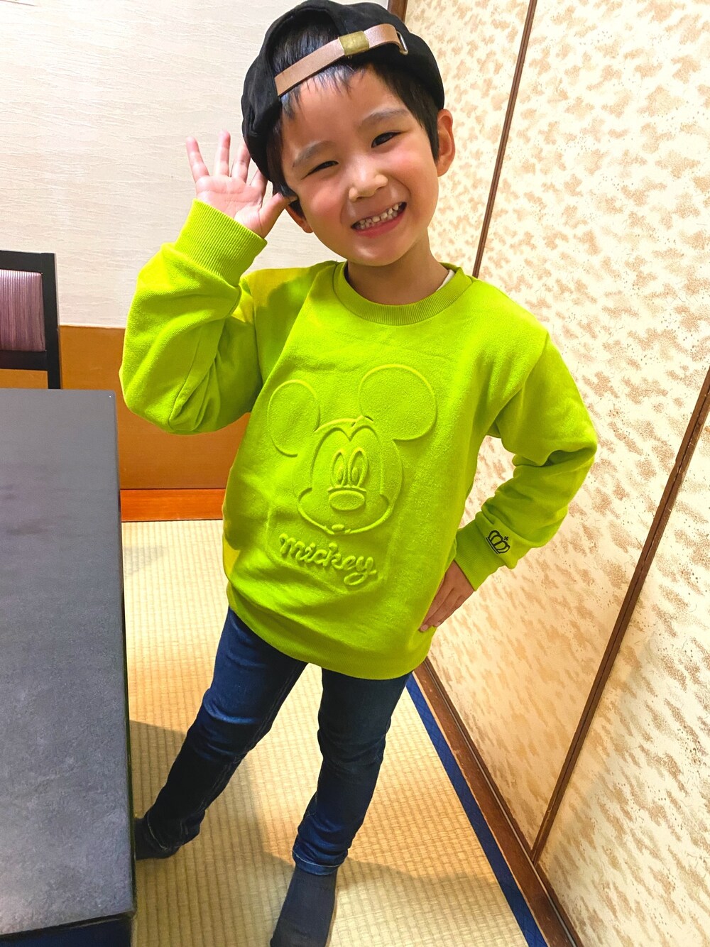 グリーン系のニット/セーター、ブルー系のデニムパンツ、ブラック系の帽子を着用したキッズの冬コーディネートの1枚目の写真