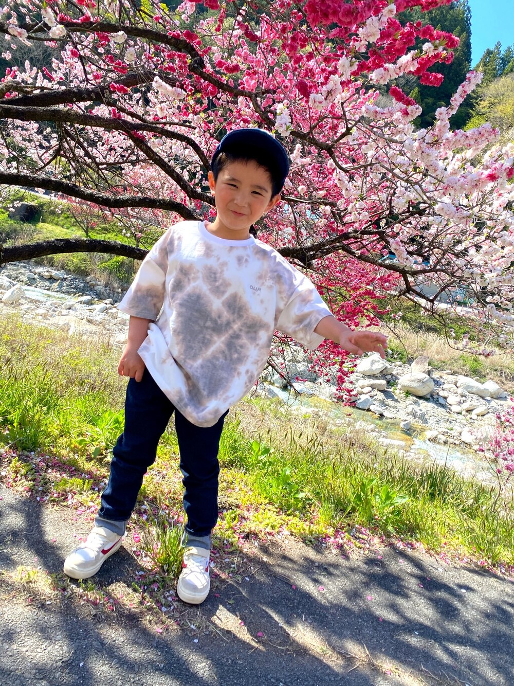 ブラウン系のTシャツ/カットソー、ブルー系のデニムパンツ、ホワイト系のスニーカーを着用したキッズの春コーディネートの1枚目の写真