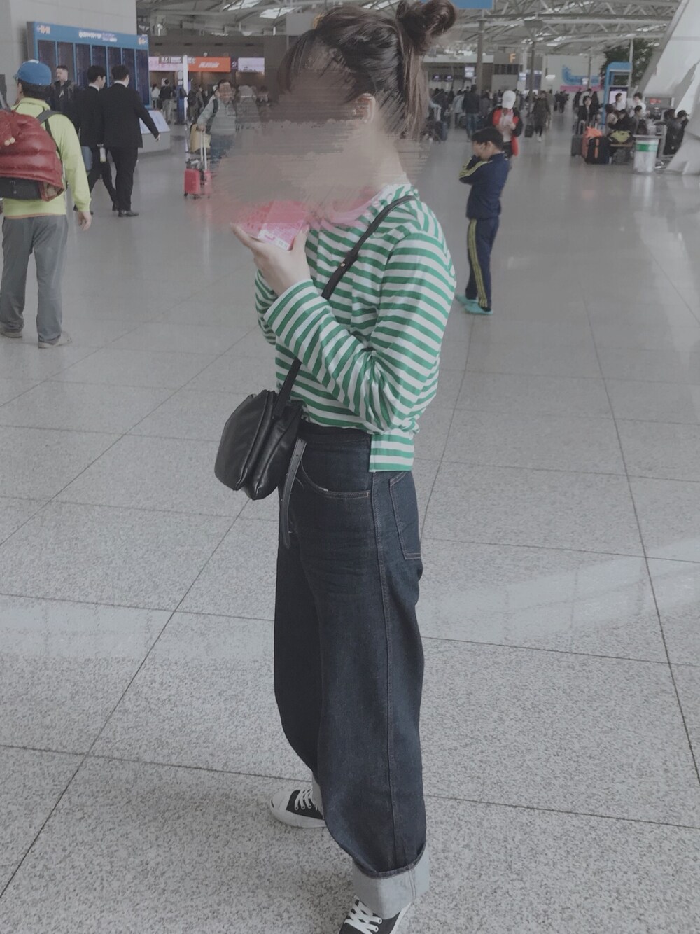 グリーン系のTシャツ/カットソー、ブルー系のデニムパンツ、ブラック系のスニーカーを着用したレディースの春コーディネートの1枚目の写真