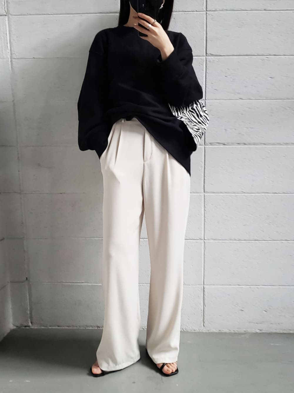 ホワイト系のセットアップ、ブラック系のハットを着用したレディースの春コーディネートの1枚目の写真