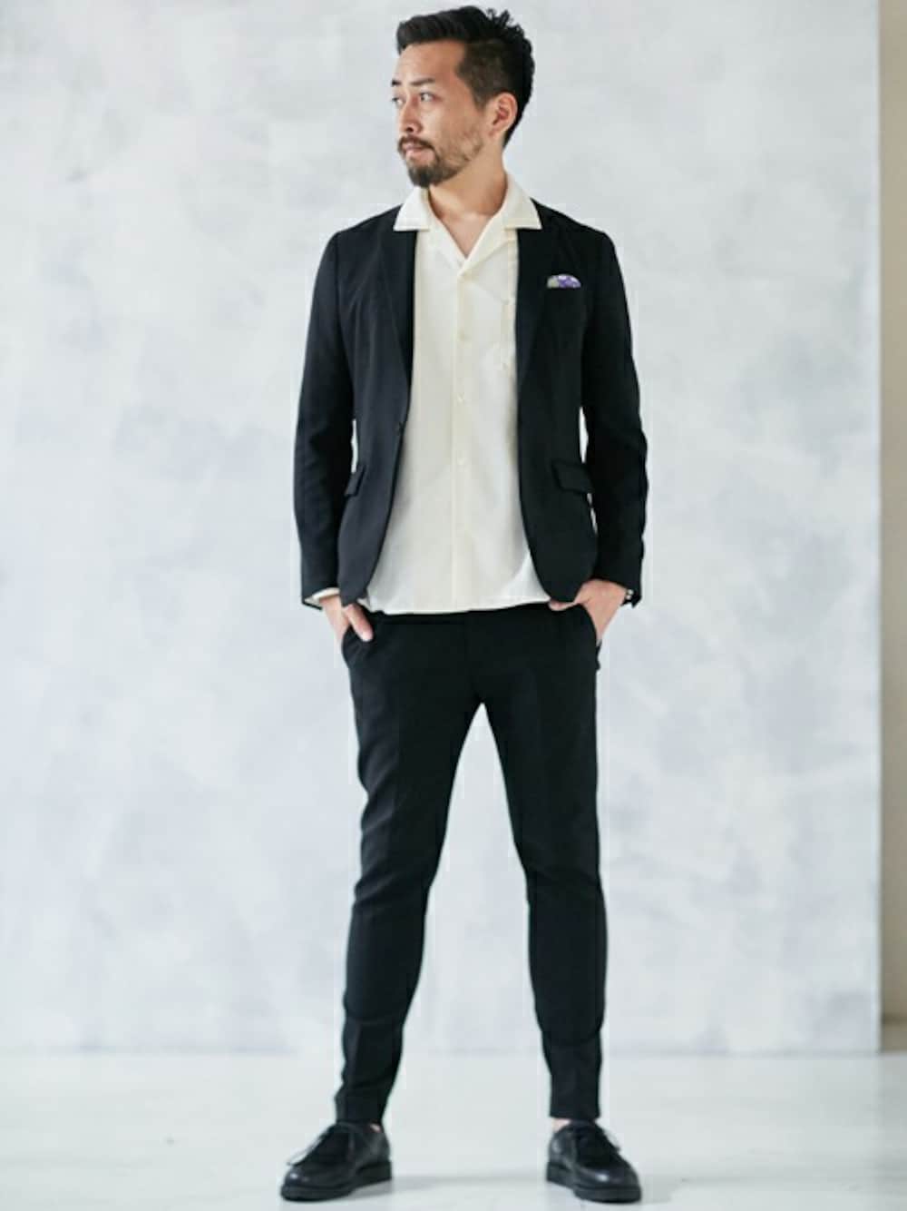 ブラック系のテーラードジャケット、ブラック系のスラックス、ブラック系のドレスシューズを着用したメンズの秋コーディネートの1枚目の写真