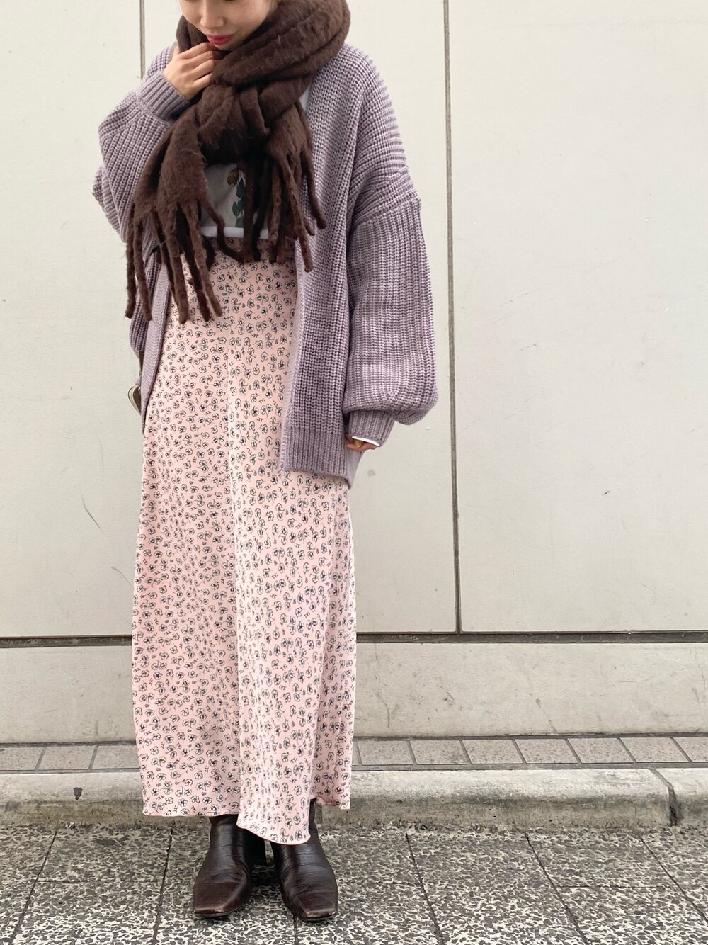 グレー系のカーディガン/ボレロ、ピンク系のスカート、ブラウン系のストール/ショールを着用したレディースの冬コーディネートの1枚目の写真