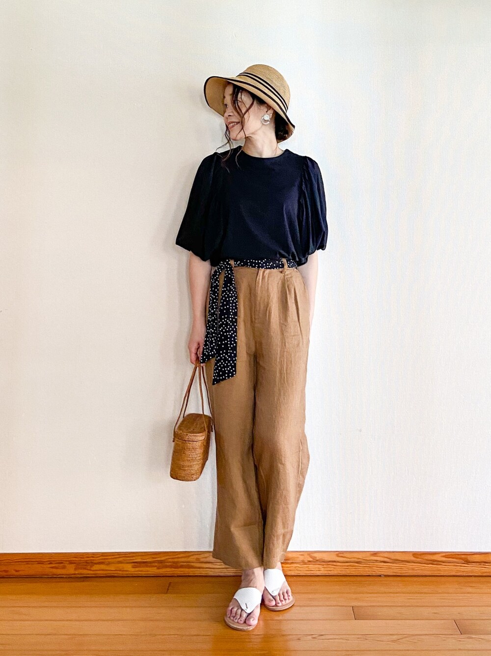 ブラック系のシャツ/ブラウス、ベージュ系のその他パンツ、ホワイト系のサンダルを着用したレディースの春コーディネートの1枚目の写真