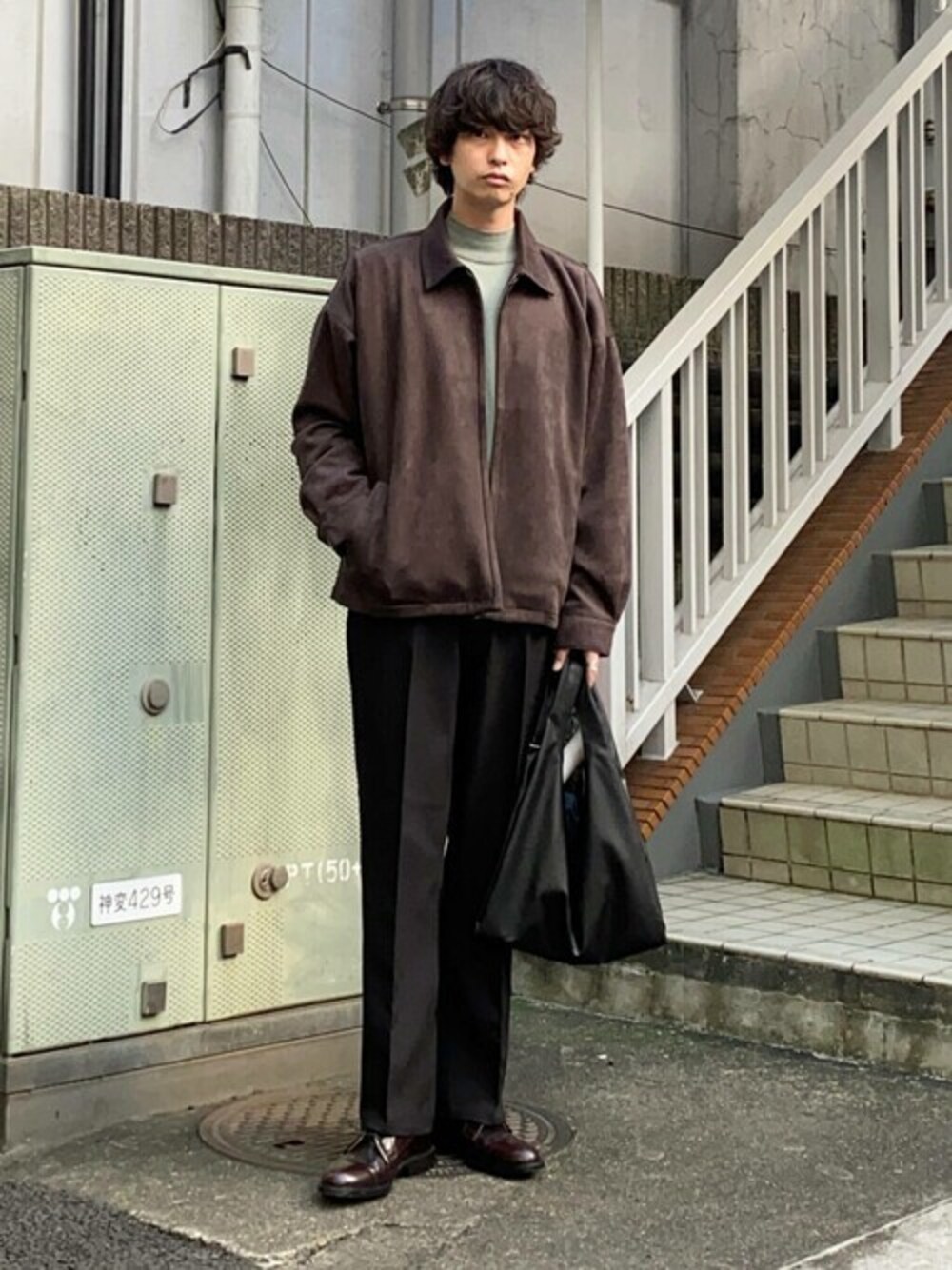 グレー系のブルゾン、グリーン系のニット/セーター、ブラック系のスラックスを着用したメンズの秋コーディネートの1枚目の写真