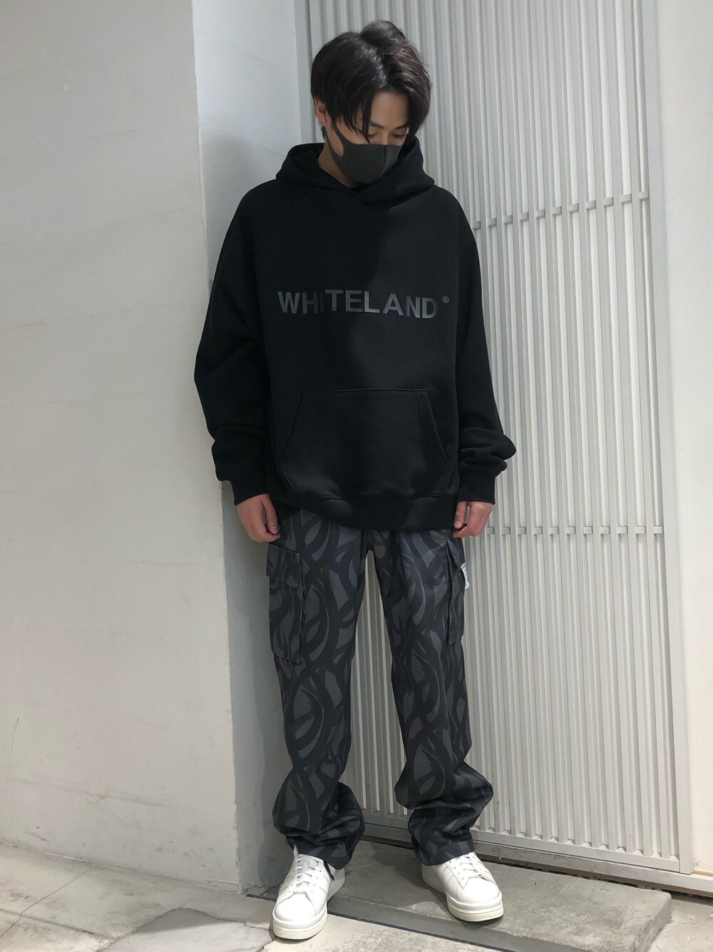 ブラック系のパーカー、グレー系のカーゴパンツ、ブラック系のパーカーを着用したメンズの春コーディネートの1枚目の写真