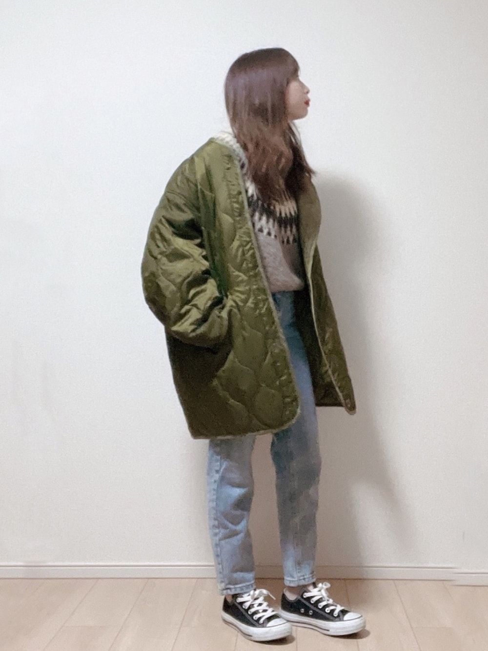 グリーン系のノーカラージャケット、グリーン系のニット/セーター、ブルー系のデニムパンツを着用したレディースの冬コーディネートの1枚目の写真