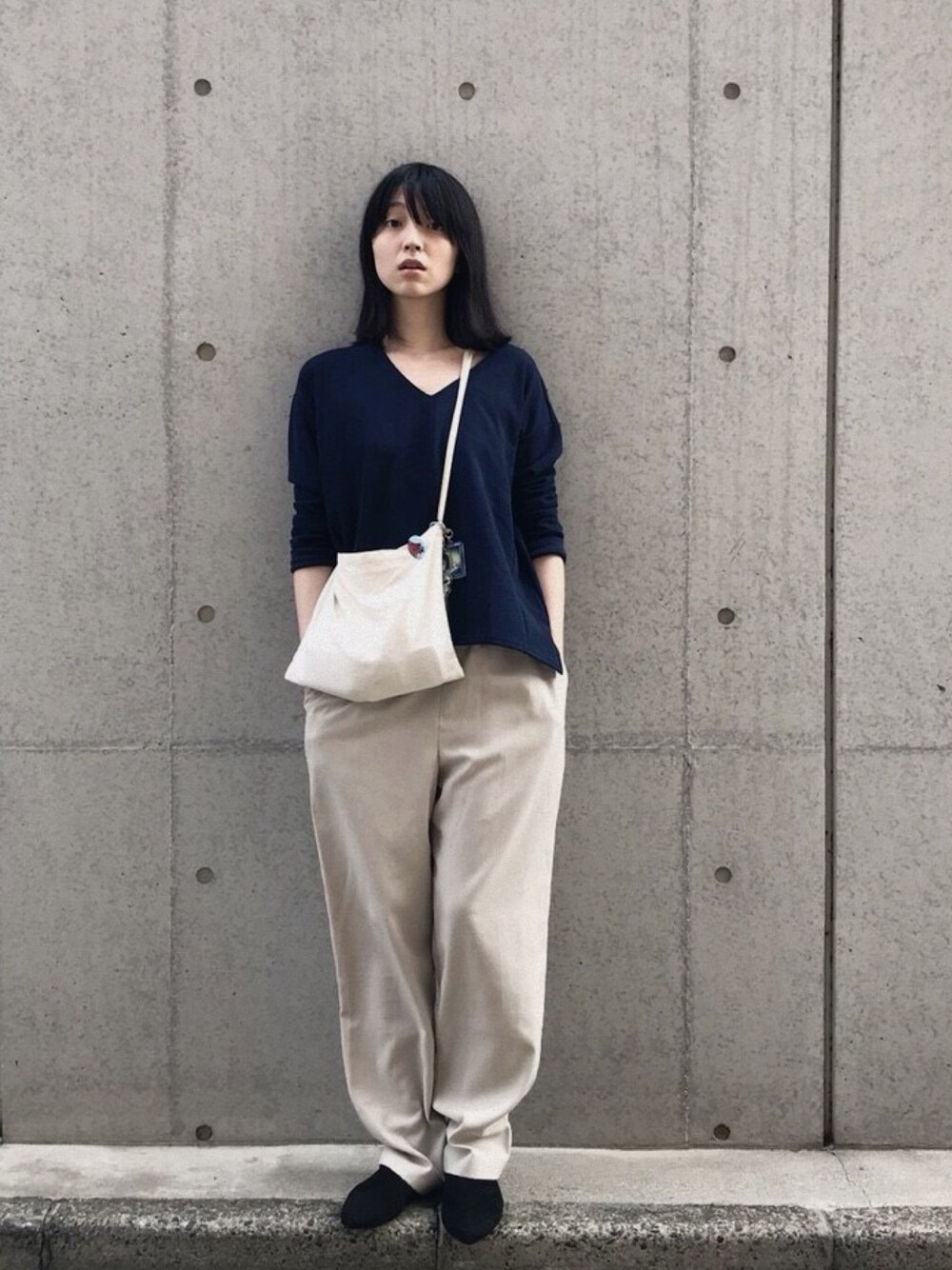 ブラック系のその他シューズ、ベージュ系のスラックス、ブルー系のTシャツ/カットソーを着用したレディースの秋コーディネートの1枚目の写真