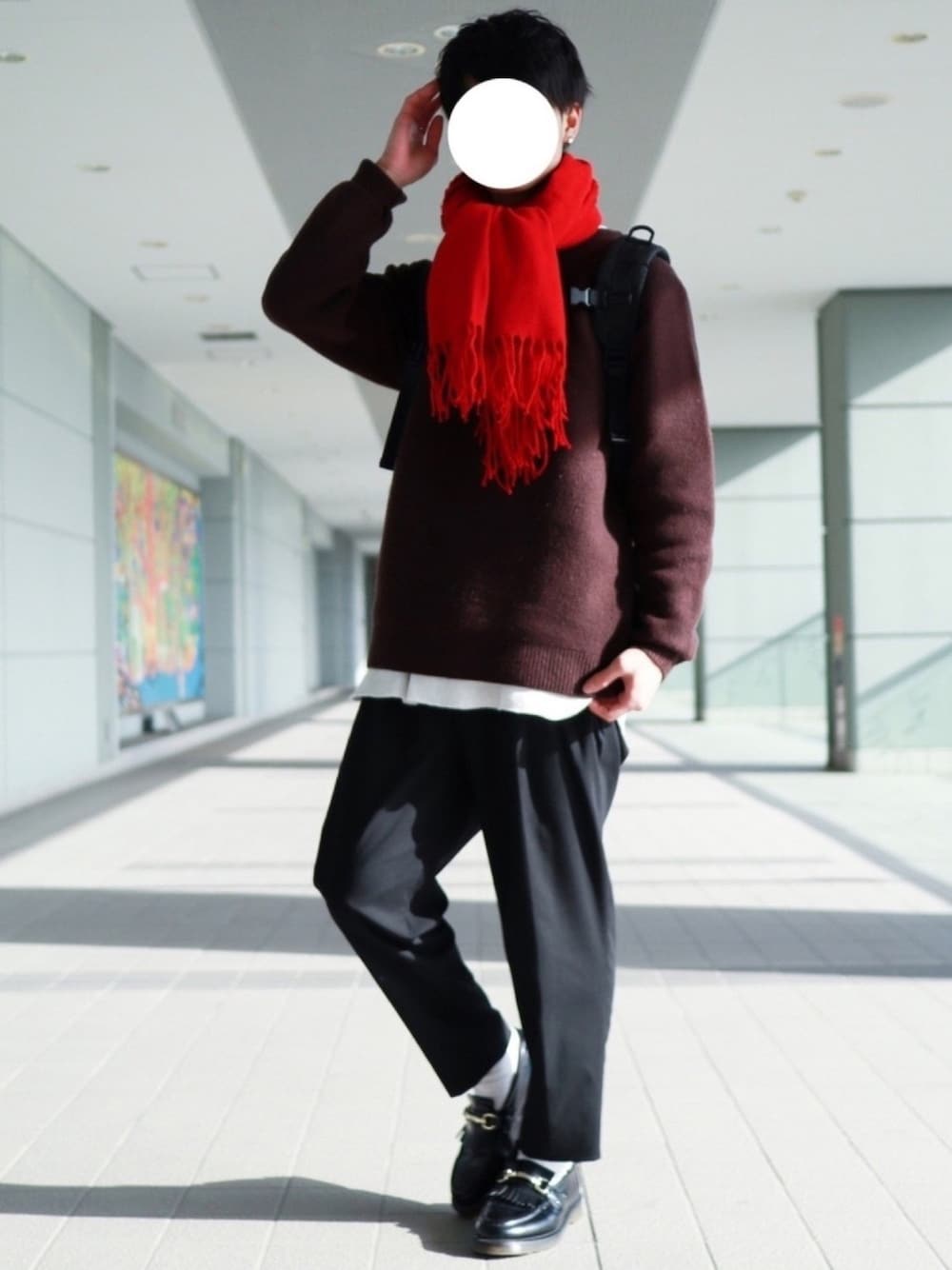 ブラウン系のニット/セーター、ホワイト系のタンクトップ、ブラック系のスラックスを着用したメンズの冬コーディネートの1枚目の写真