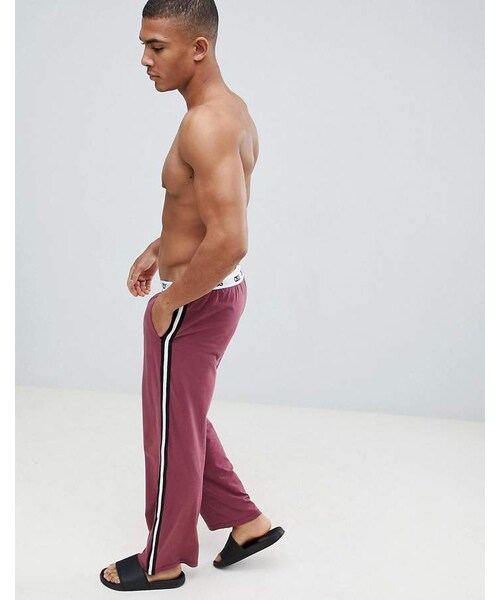 asos(エイソス)の「ASOS DESIGN straight leg jersey pyjama bottom in burgundy with branded waistband(デニムパンツ・メンズ・Red・M/XL/XXXL/XXS/S/XS/XXL/L)」の1枚目の写真
