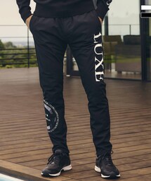 LUXEAKMPLUS（リュクスエイケイエムプラス）の「LUXEAKMPLUS(リュクスエイケイエムプラス)サークルロゴウィンドパンツ（パンツ）」