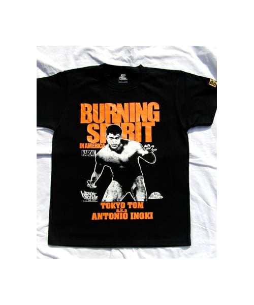 ハードコアチョコレート(ハードコアチョコレート)の「BURNING SPIRIT IN AMERICA(アントニオ猪木)若獅子オレンジ(Tシャツ/カットソー・メンズ・ブラック・160/S/M/L/XL/XXL)」の1枚目の写真